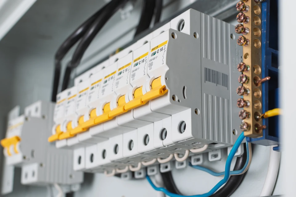 Électricien professionnel effectuant des mesures électriques dans un intérieur résidentiel