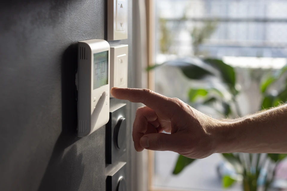 Électricien professionnel en extérieur près de son fourgon utilitaire blanc, portant casque de sécurité blanc et gants de protection